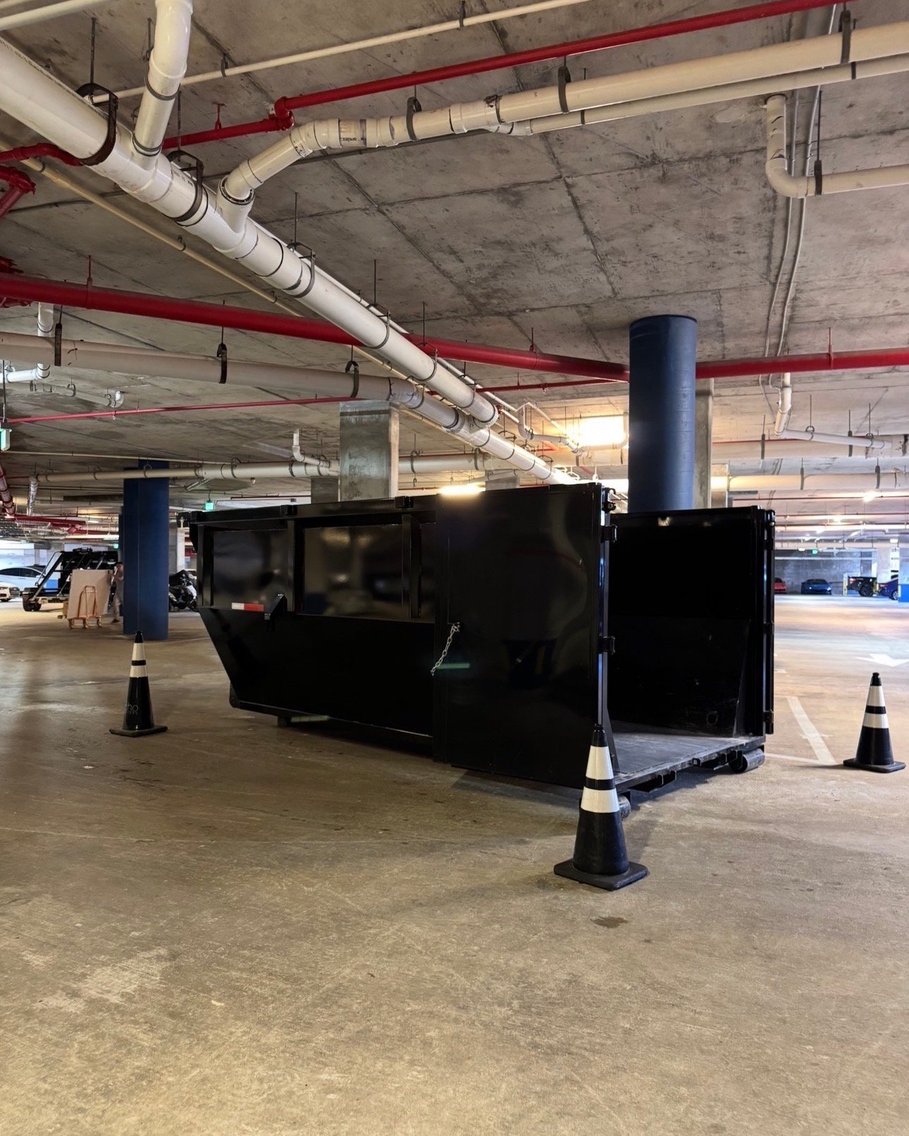 Commercial dumpster rental Miami high-rise. Barraza Industries underground parking garage placement