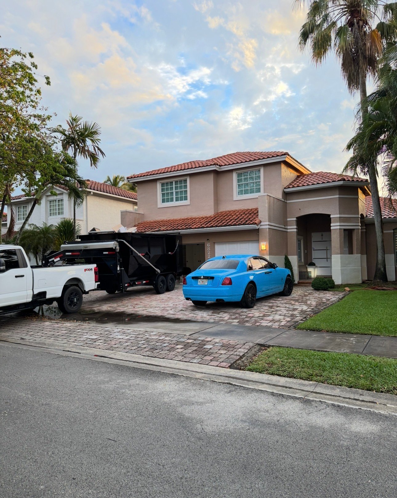 Luxury home dumpster rental Miami. Barraza Industries Ford F-350 and roll-off dumpster trailer at Gables Estates property